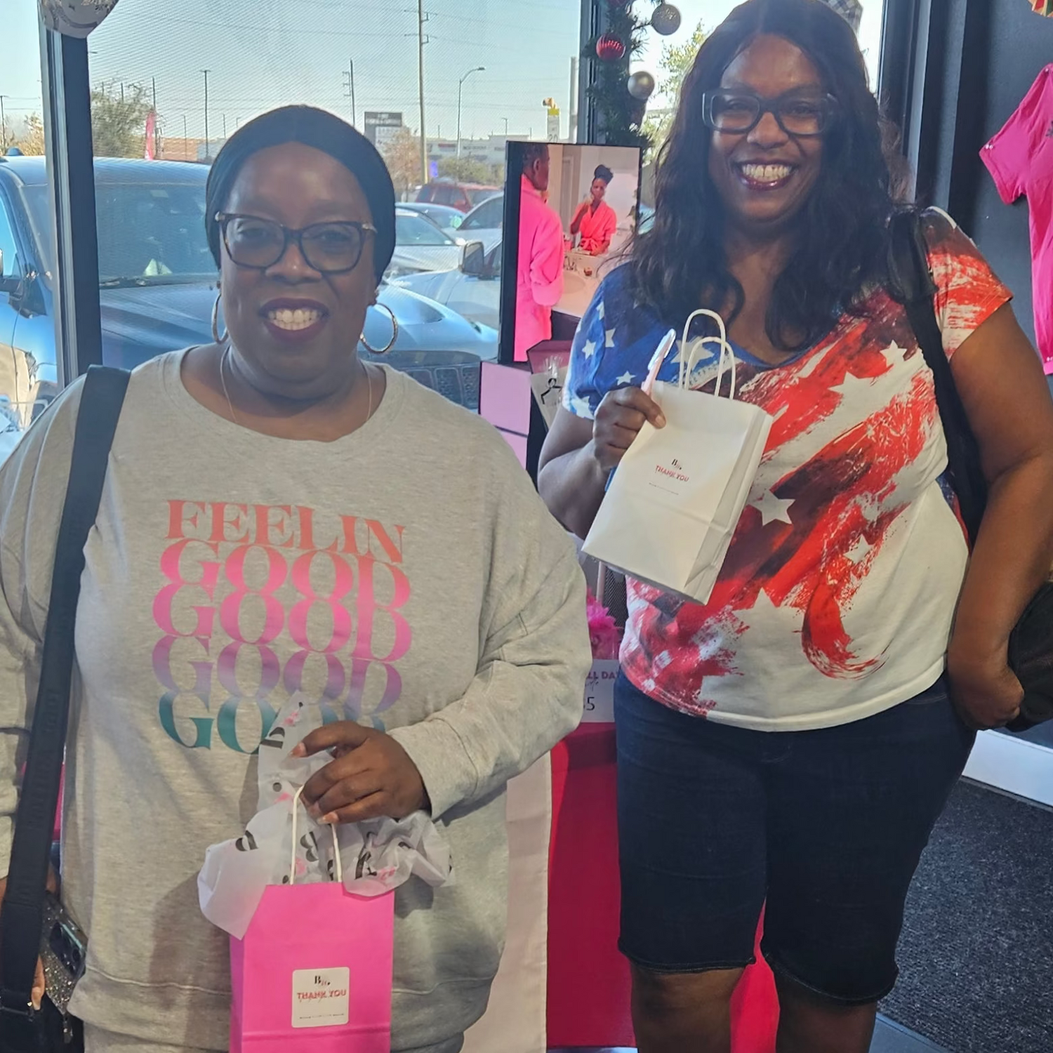Customers holding bright pink by A’amia shopping bags at A&E Beauty Supply.