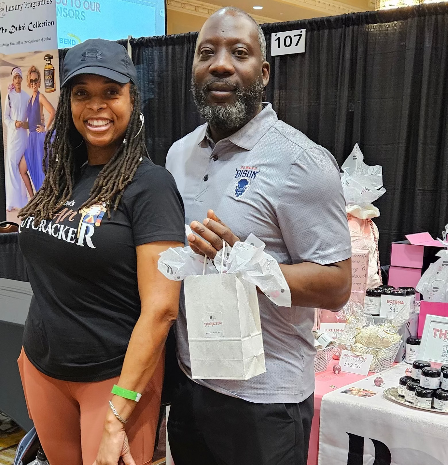 Couple at the Holiday Soul Market with a by A’amia shopping bag.