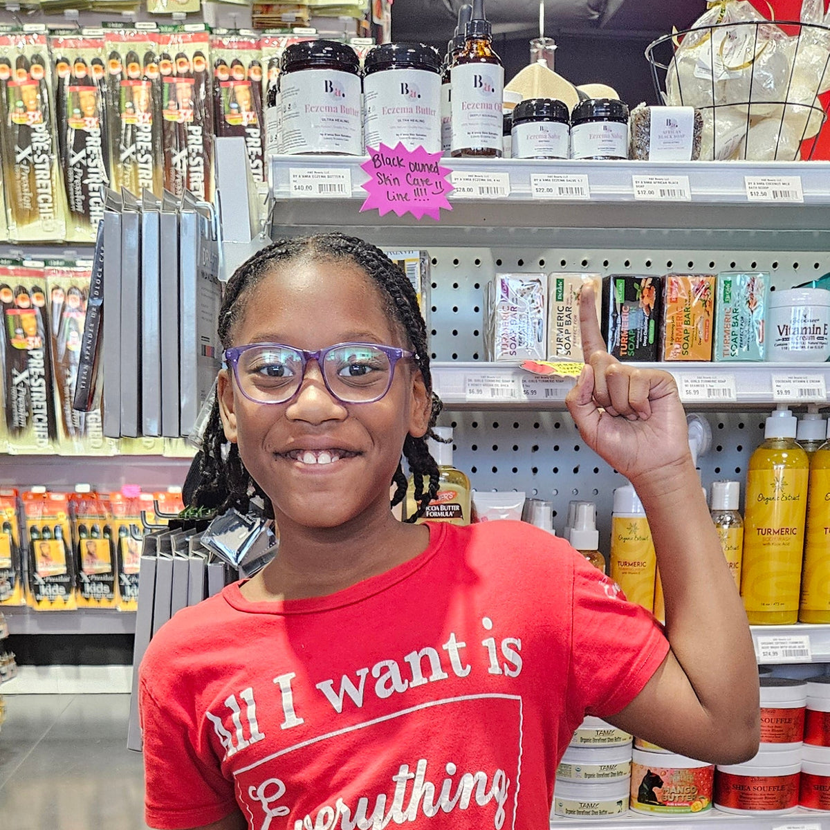 Young by Aβamia family member standing beside the retail shelf at A&E Beauty Supply.