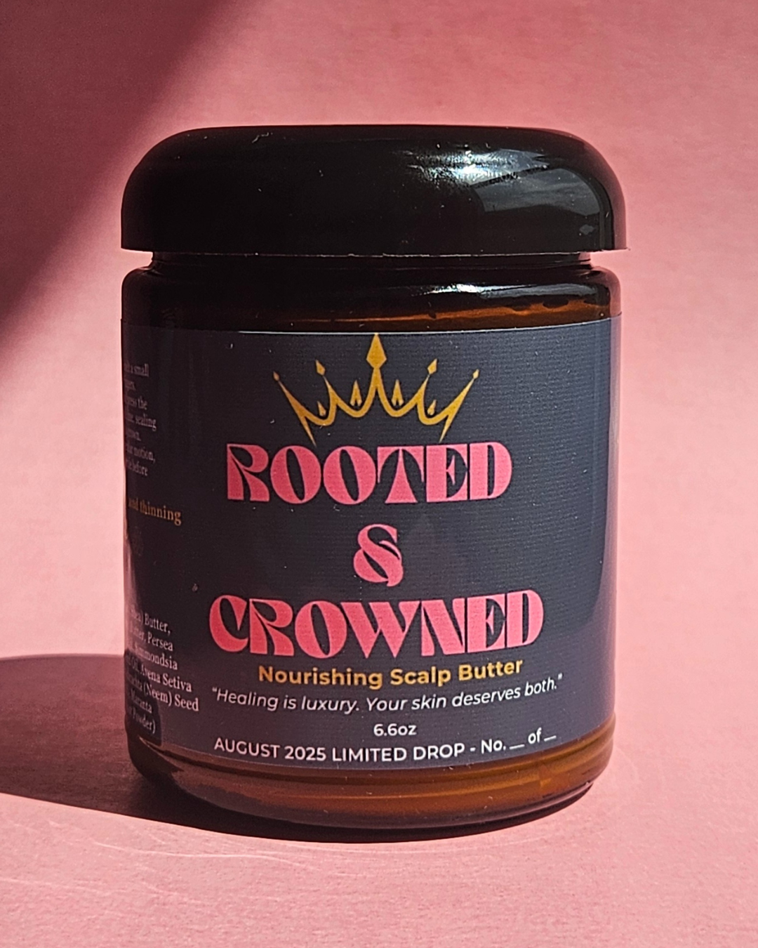 Nourishing Scalp Butter by Rooted & Crowned in a black jar with pink label, showcased on a soft pink background for a luxury presentation.