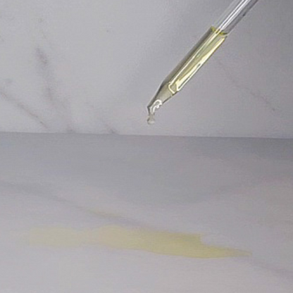 Dropper dispensing by A’amia Eczema Oil to show its lightweight liquid-gold texture.