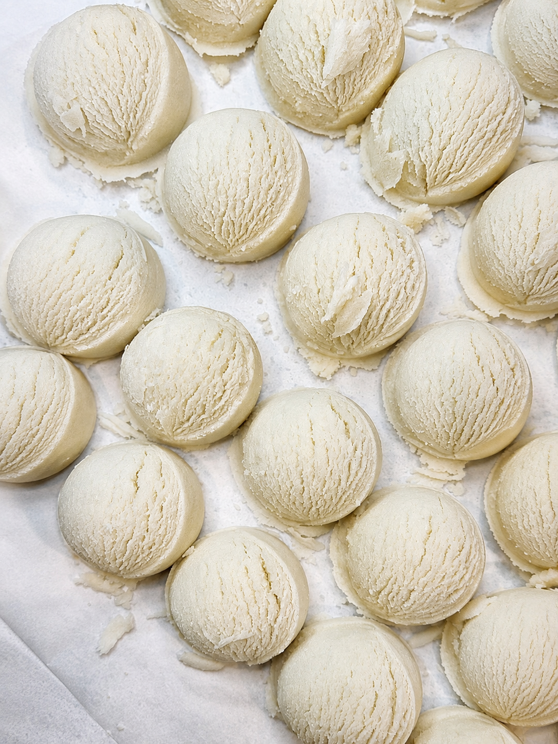 Close-up flat lay of by A’amia Coconut Milk Bath Scoops showing the creamy handmade texture of the fragrance-free bath soak.